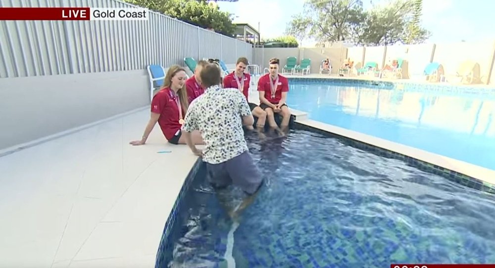一名英国记者采访时在泳池里滑倒