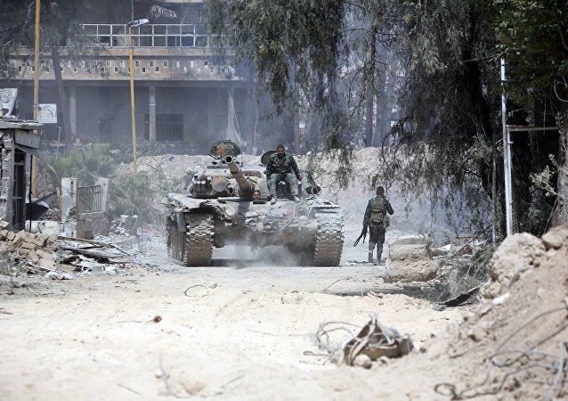 Syrian Army soldiers advancing in an area on the eastern outskirts of Douma
