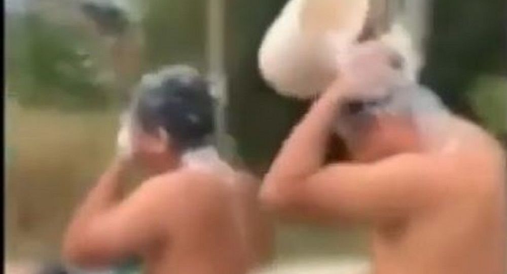 俩男子在越南边骑车便洗澡 视频疯传后被罚款 